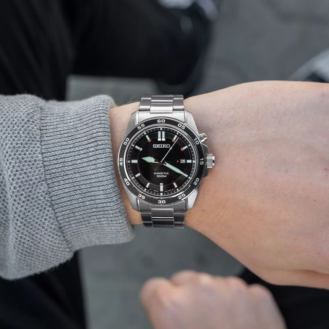 Đeo trên tay Đồng hồ Seiko 100m SKA785P1 mặt đen có ký hiệu Kinetic ở mặt số,