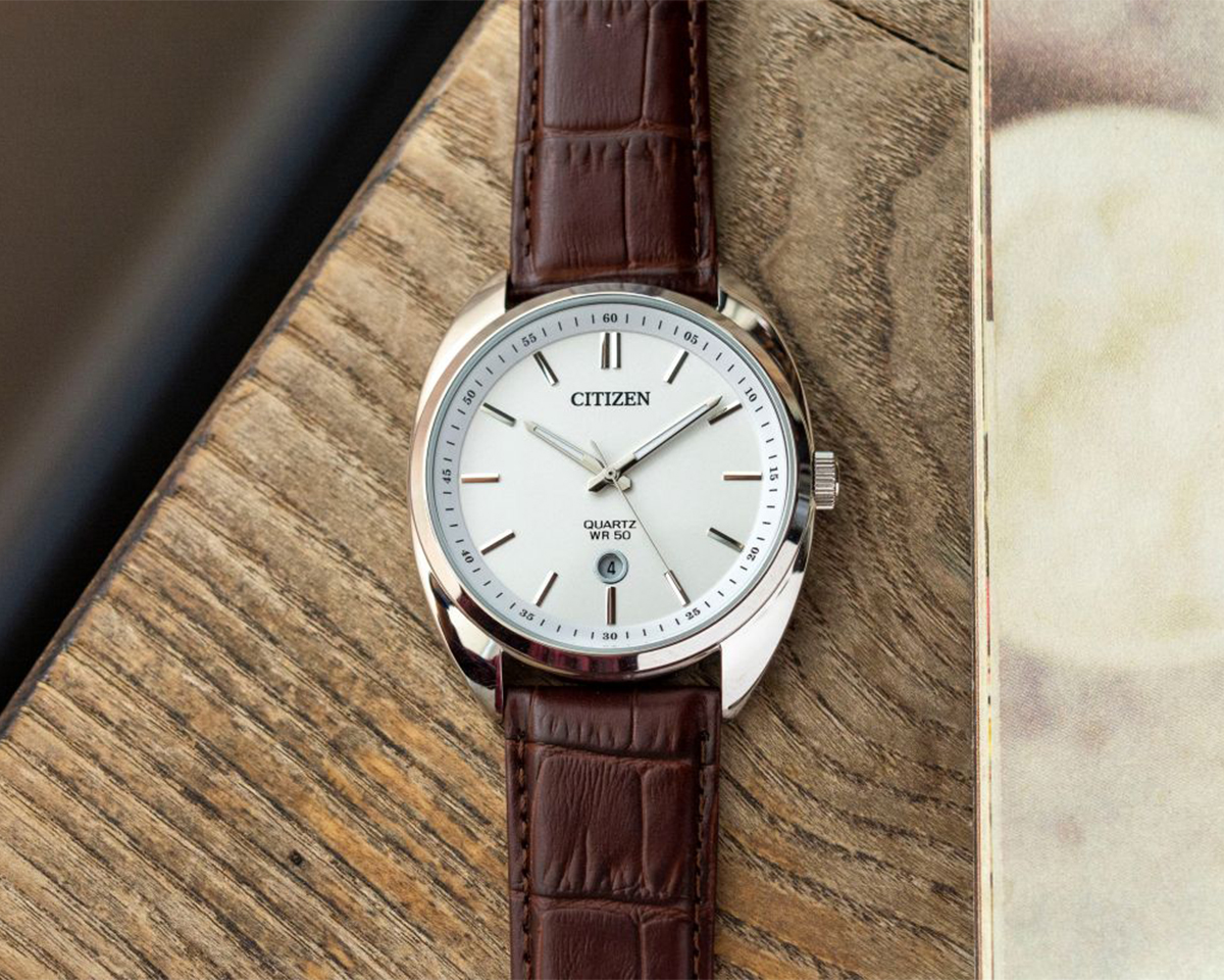 Cận cảnh đồng hồ Citizen Quartz WR50 BI5090-09A mặt số trắng, vỏ thép không gỉ sáng bóng kết hợp cùng dây da bò màu nâu.