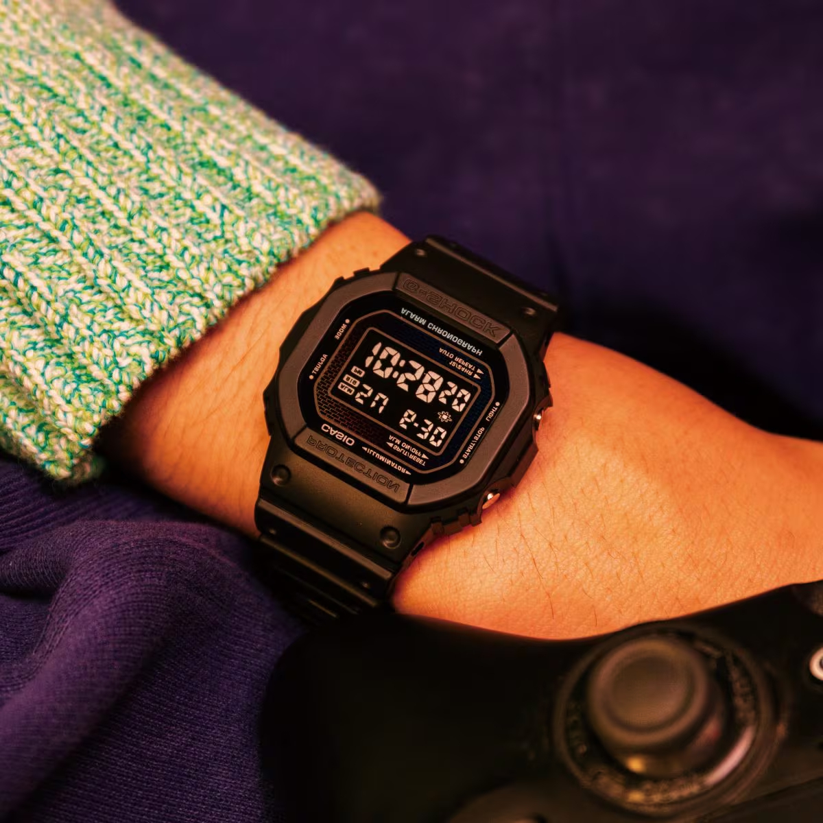 Đồng hồ G-Shock DW-5600 màu đen đeo trên cổ tay, nổi bật màn hình âm và thiết kế mặt vuông cá tính.