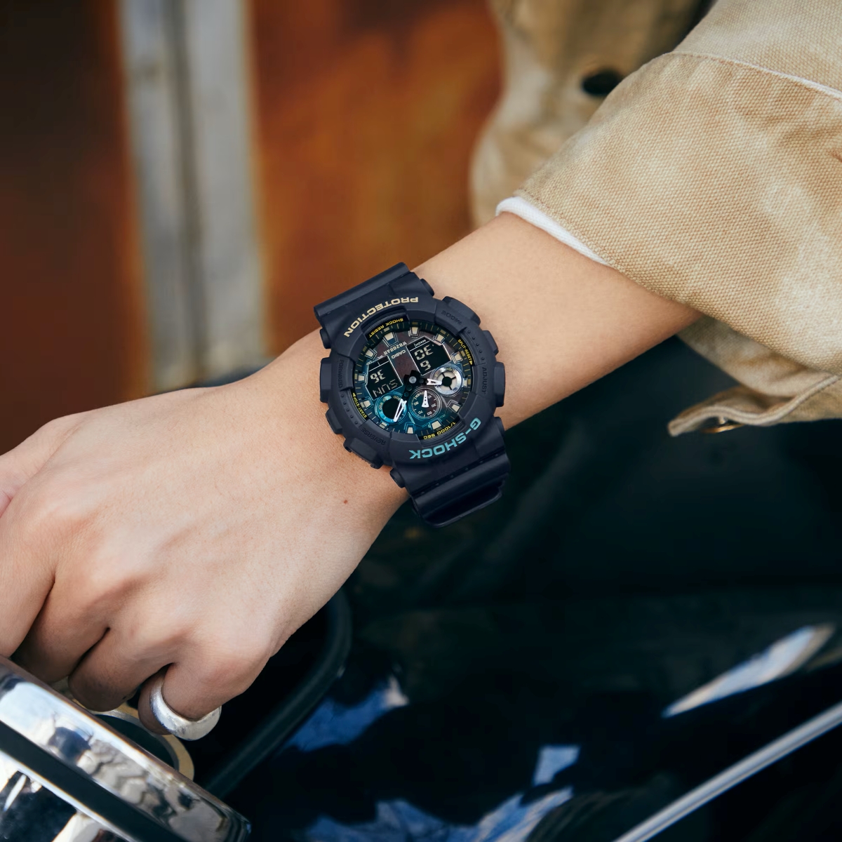 Đồng hồ G-Shock kim điện tử phối xanh vàng đeo trên cổ tay.