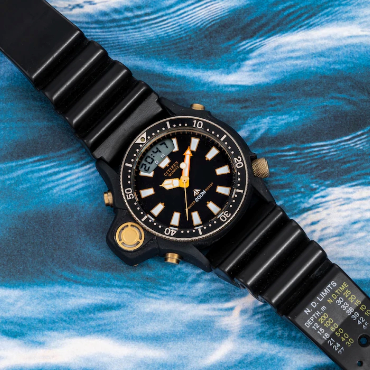 Đồng hồ Citizen Aqualand vintage phiên bản 1985 đặt trên nền họa tiết sóng biển.