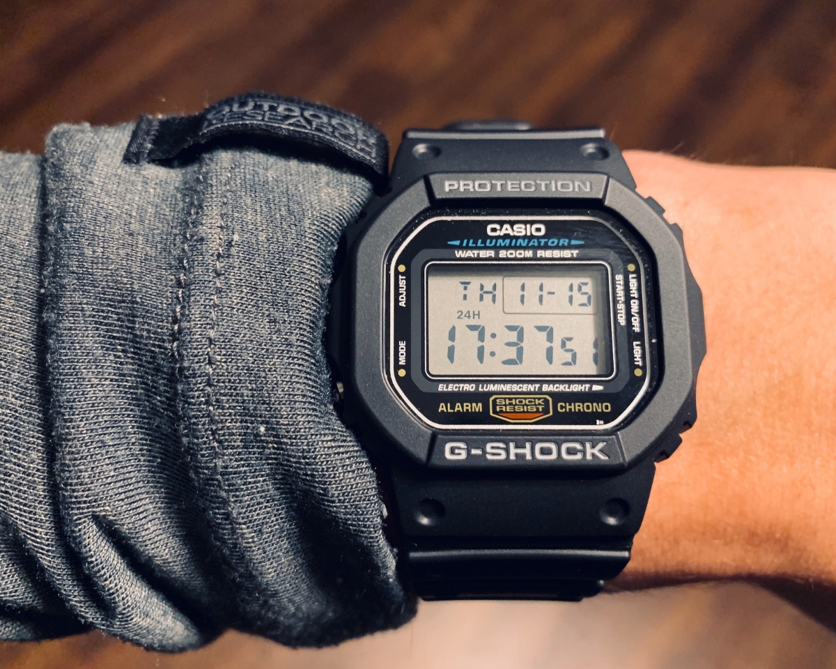 Đồng hồ G-Shock DW-5600 màu đen đeo trên cổ tay, thiết kế mặt vuông gọn gàng và dễ phối đồ hằng ngày.