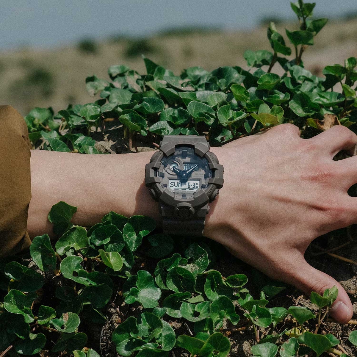 Đồng hồ G-Shock GA-700 màu xanh rêu đeo trên cổ tay ngoài trời.