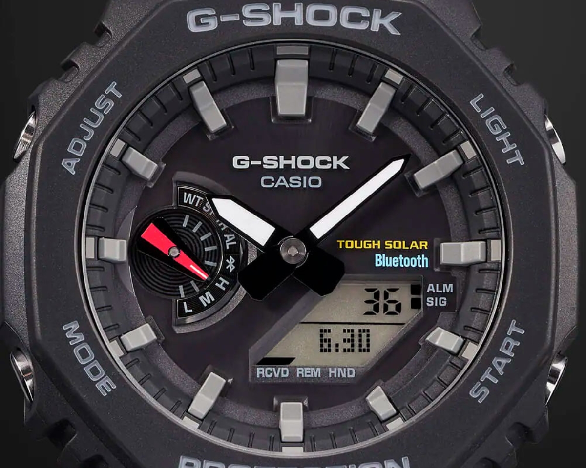 Cận cảnh mặt số G-Shock GA-B2100 màu đen với kim chỉ giờ, màn hình điện tử, Tough Solar và Bluetooth.