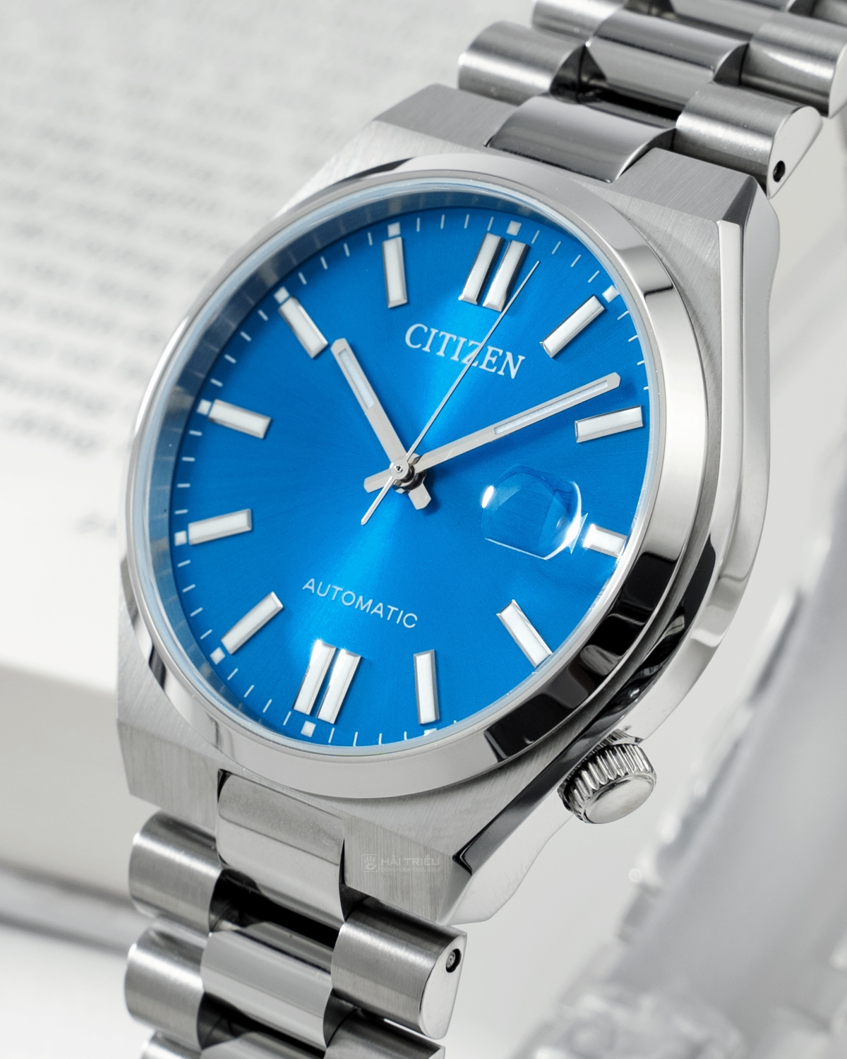 Cận cảnh mặt số màu xanh dương nổi bật của đồng hồ nam Citizen Tsuyosa Pantone NJ0158-89L với các kim, cọc số màu bạc, ô lịch ngày.