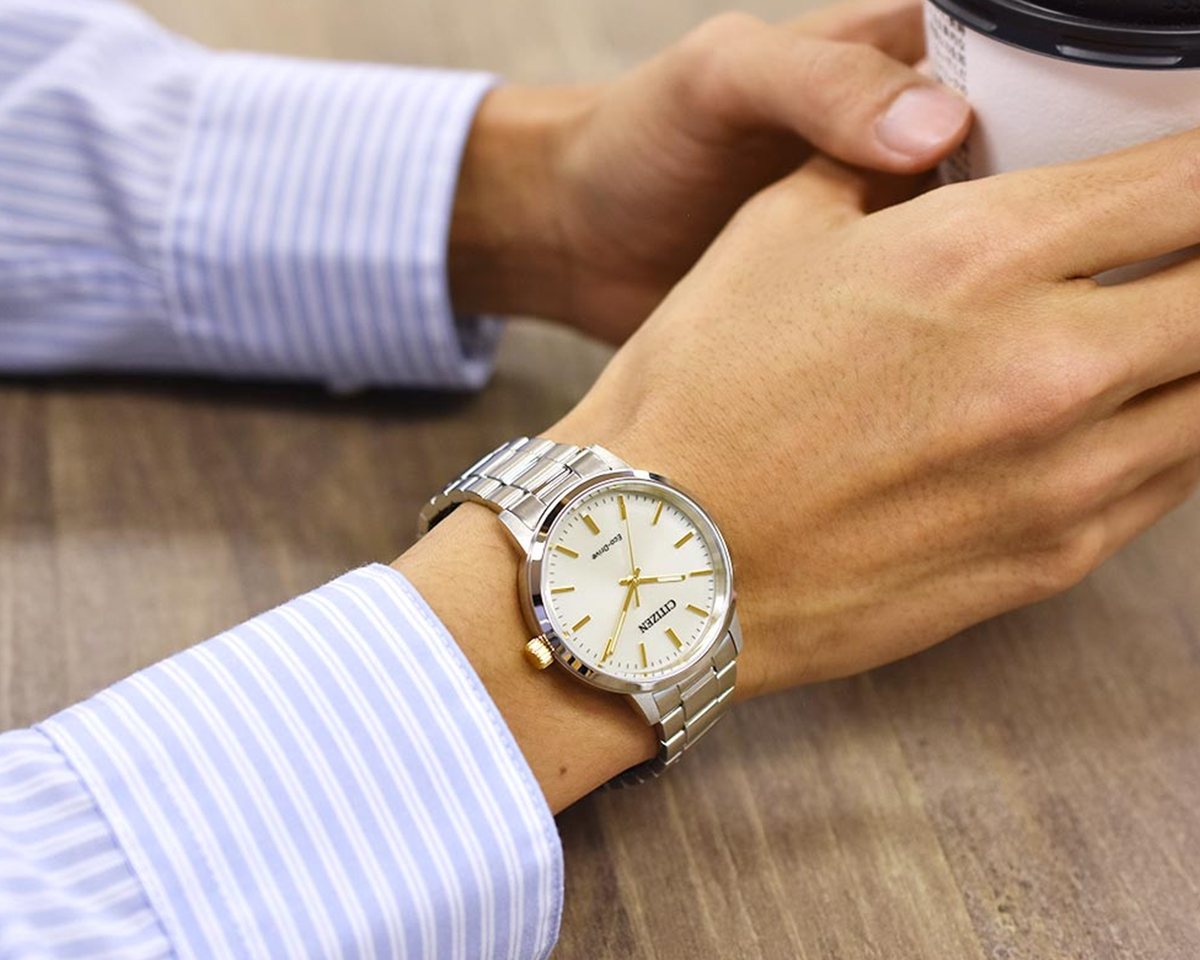 Thực tế đồng hồ Citizen Eco-Drive WR100 mã BJ6541-58P mặt số vàng nhạt, kim cọc số mạ vàng thanh mảnh cùng dây kim loại phay xước.