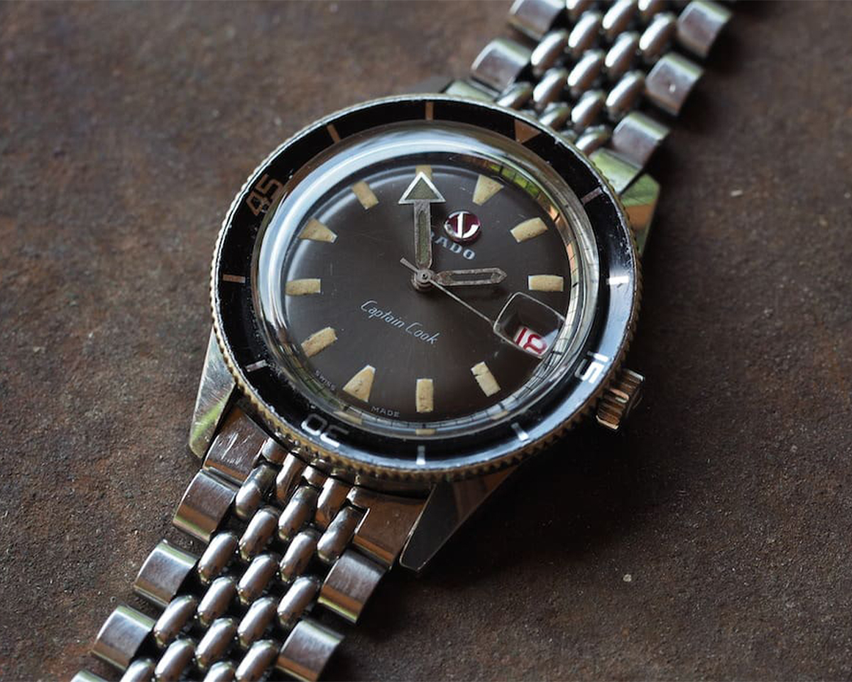 Mẫu đồng hồ Rado Captain Cook thập niên 1960 với dáng lặn cổ điển bezel xoay và logo mỏ neo đặc sắc.