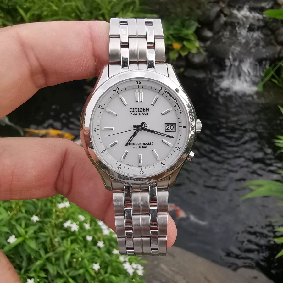 Tay cầm đồng hồ Citizen Eco-Drive Radio Controlled mặt trắng dây kim loại chụp ngoài trời.