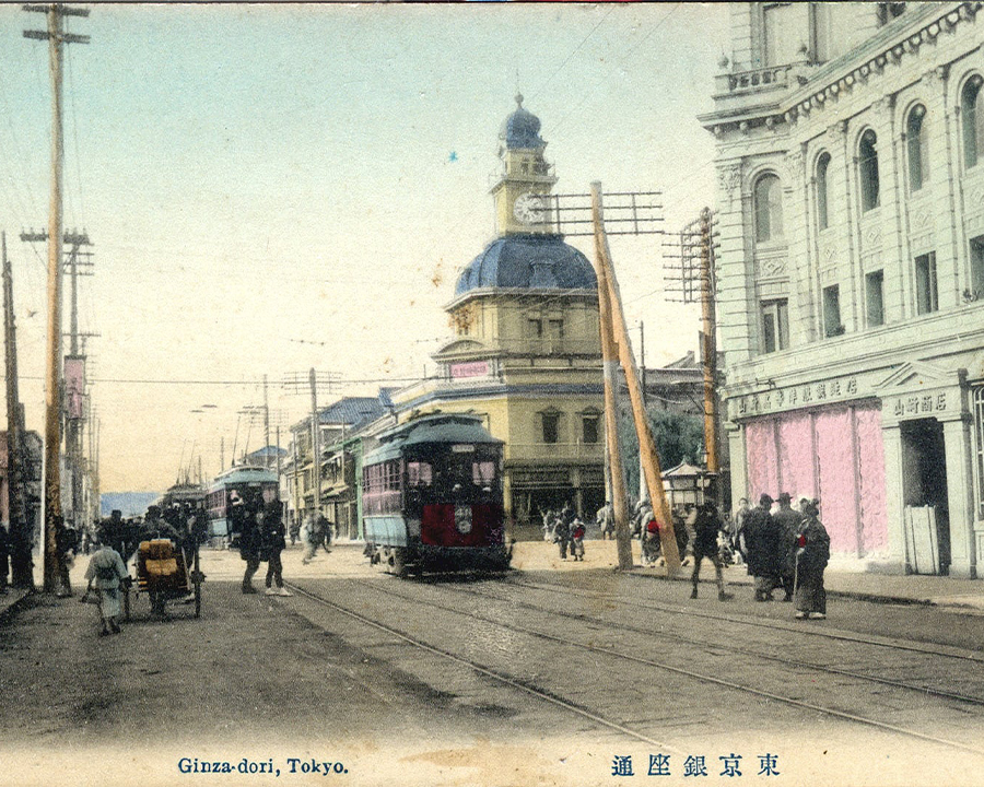 Bưu thiếp cổ về Ginza-dori, Tokyo, nổi bật với tháp đồng hồ Hattori/Seikosha, xe điện màu đỏ và người đi bộ.