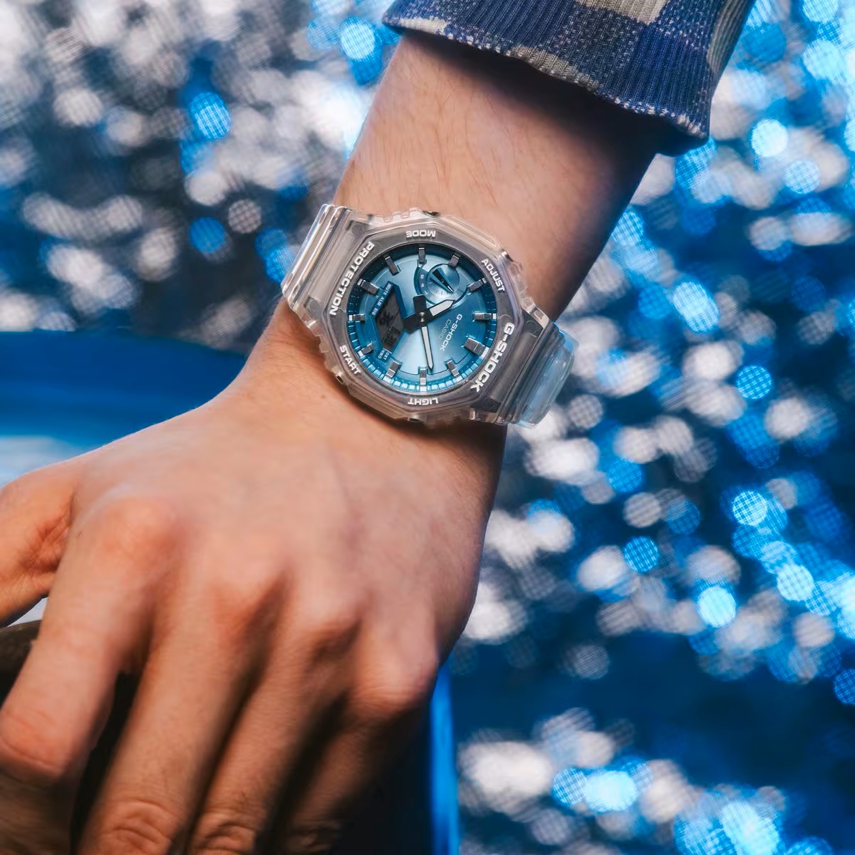 GA-2100BM-7A2 với phần dây trong suốt và mặt số màu xanh dương thu hút.