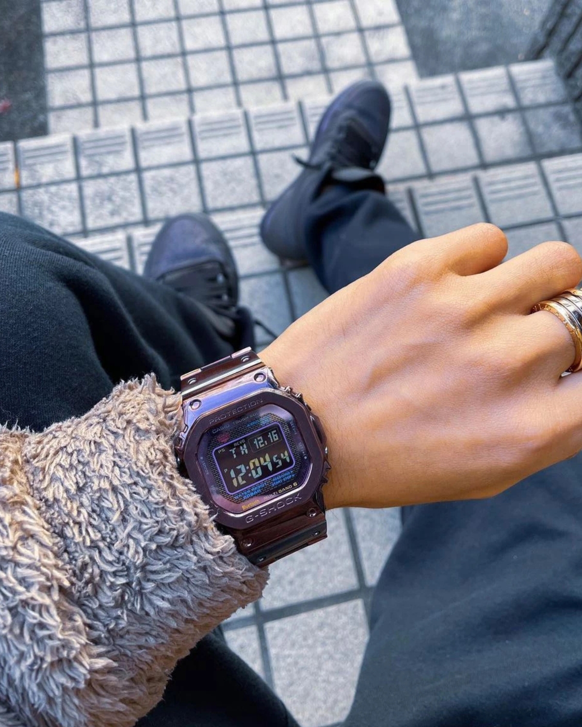 Đồng hồ G-Shock tím kim loại trên cổ tay nam.