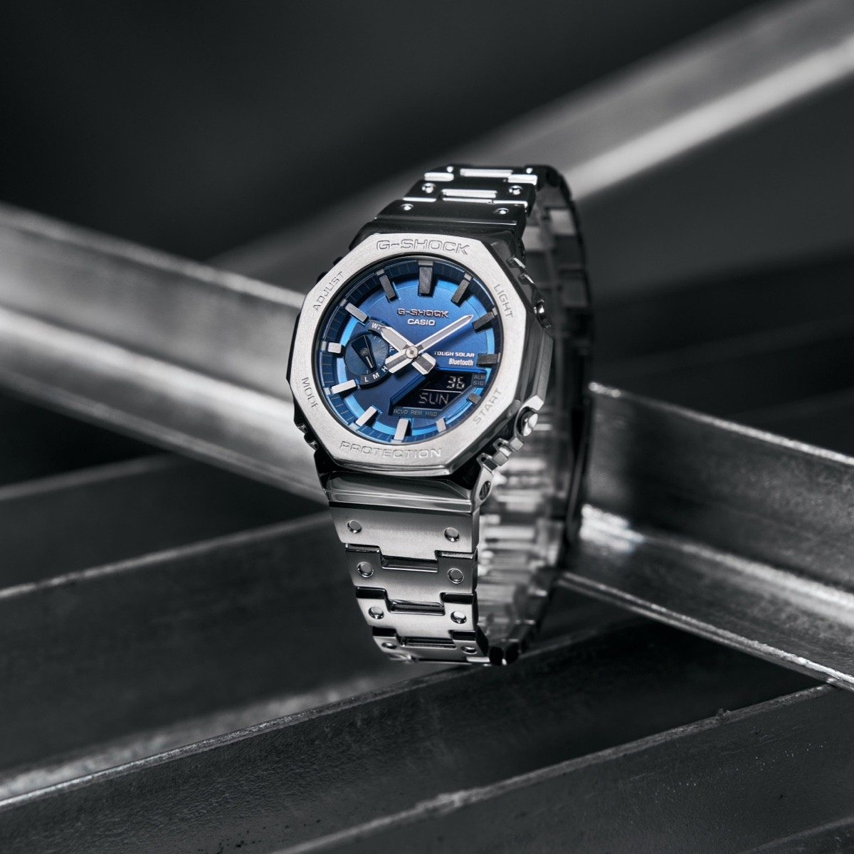 Đồng hồ GM-B2100AD-2A sử dụng bezel và dây thép không gỉ kết hợp mặt số xanh metallic.
