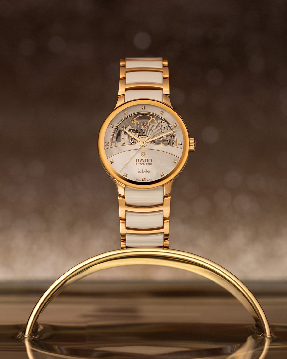 Mặt số Rado Centrix Open Heart tạo hình cây cầu bằng những đường cong mềm quanh ô cửa lộ cơ tinh tế.